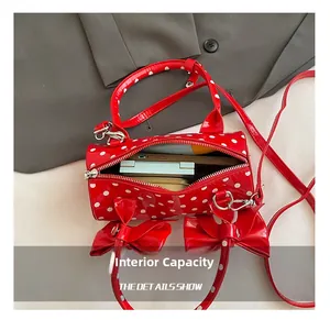 Capacité interne du sac polochon rouge à pois avec téléphone et cosmétiques