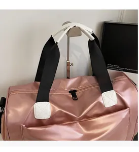 Detalle de bolsa de viaje oro rosa con asas reforzadas y acabado impermeable
