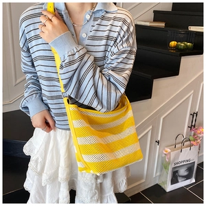 Detail of a lightweight yellow and white striped mesh tote bag for casual summer vacations