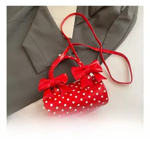 Détail du sac cylindrique rouge à pois avec deux grands nœuds décoratifs élégants