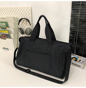 Détail d'un grand sac de voyage noir en nylon avec une bandoulière amovible réglable