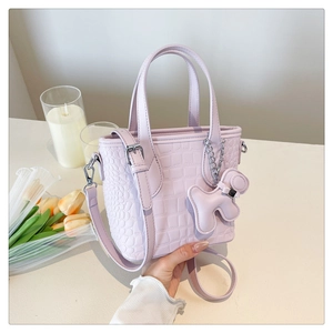 Lavender bucket bag with crocodile texture, twin handles and cute bear charm detail