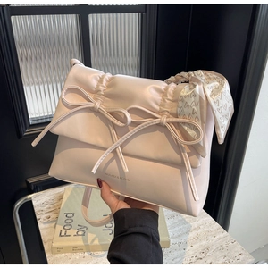 Détail du sac à bandoulière bouffant rose pâle avec nœud et foulard à cœurs