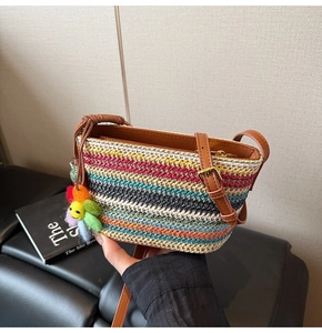 Détail du sac bohème tissé coloré avec motif à vagues arc-en-ciel et breloque florale