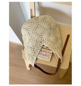 Close-up of the beige crochet sunflower tote bag with brown leather strap detail