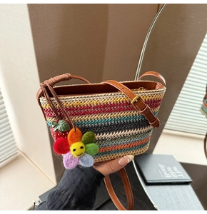 Détail du sac tissé arc-en-ciel avec pendentifs de fraise et de fleur de soleil