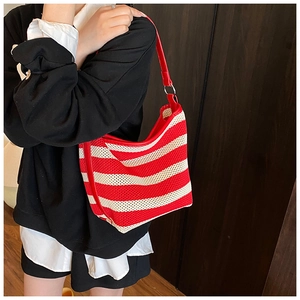 Detail of red and white striped woven mesh tote bag with smooth faux leather trim