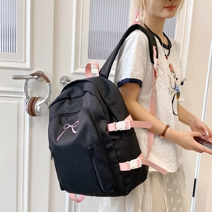 Détail du sac à dos scolaire noir et rose avec broderie nœud et boucles latérales