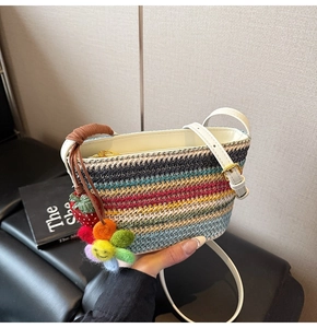 Détail du sac seau en paille arc-en-ciel avec pendentifs fraise et tournesol