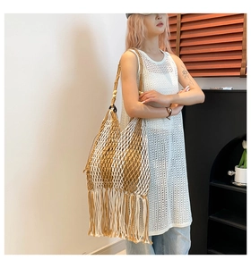 Close-up of bohemian woven tote bag featuring beige and brown fringe and wood bead details