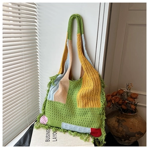 Detail of the colorful knitted tote bag with fringe edges and hollow weave pattern texture