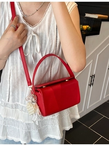 Fashionable red top-handle crossbody bag with heart pearl charm and lace bow detail