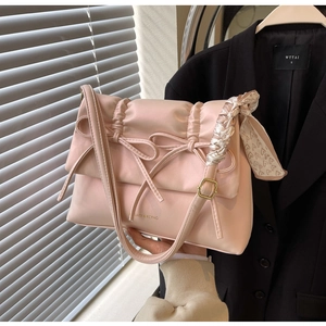 Sac sous le bras en cuir mat rose avec des nœuds décoratifs et un foulard en soie