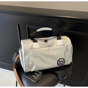 Sac de voyage en nylon gris argenté de grande capacité sur une chaise avec bandoulière