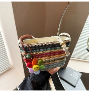 Détail du sac en paille tissé coloré avec breloque fraise et pendentif tournesol arc-en-ciel