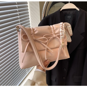 Détail du sac à bandoulière rose style ballet avec nœuds décoratifs et cuir synthétique plissé