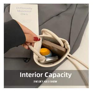 Vue détaillée de la capacité intérieure de ce mini sac seau beige pour téléphone