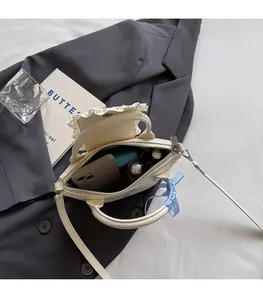 Top view showing spacious interior of the cream leather bucket bag with lace trim