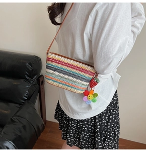 Détail du sac seau en paille colorée avec breloques mignonnes en fraise et tournesol