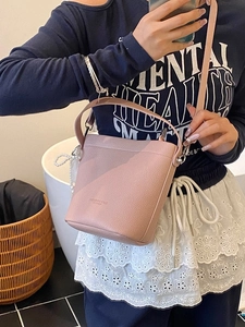 Elegante borsa a secchiello rosa in pelle martellata con ciondolo di perle