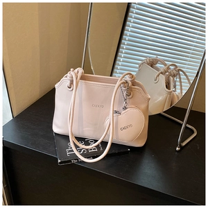 Détail du sac seau en cuir souple rose clair avec pendentif coeur assorti et marquage