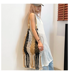 Detail of woven boho tote bag featuring tricolor cotton fringe and wooden bead accents