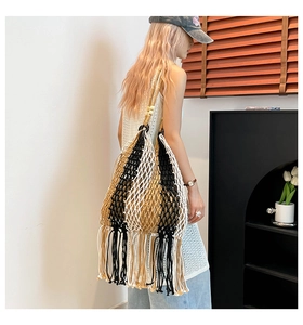 Detail of bohemian tricolor woven tote bag with long tassels and wooden bead accents