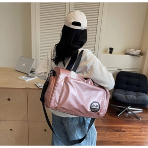 Sac de voyage rose imperméable avec fini brillant et bandoulières noires chez soi