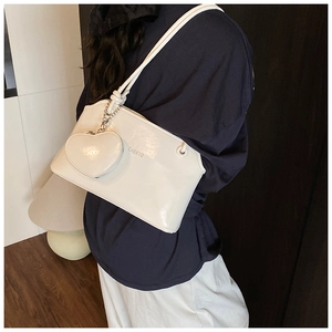 Détail du sac seau blanc avec porte-monnaie en forme de cœur et bandoulière en chaîne