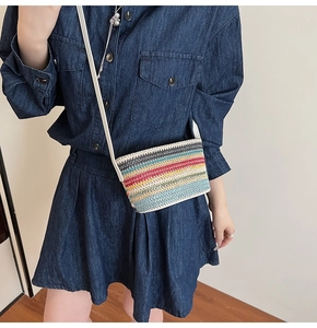 Détail d'un petit sac bandoulière tissé à rayures arc-en-ciel avec une fine lanière blanche