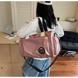 Détail du sac de sport rose en nylon imperméable avec bandoulière et poches latérales