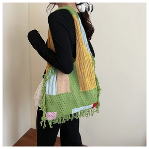 Detail of color-block knit tote bag showing bohemian fringe trim and crochet textures