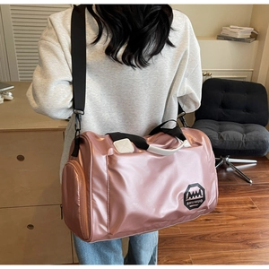 Vue détaillée du sac de voyage rose métallique montrant la poche latérale et la bandoulière