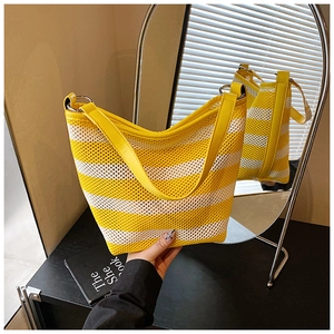 Detail of yellow and white striped mesh tote bag with smooth leather handle and metal rings