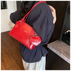 Détail du sac seau en cuir rouge avec un porte-monnaie amovible en forme de cœur