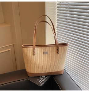 Close-up of the woven texture and brown leather trim on the summer tote bag
