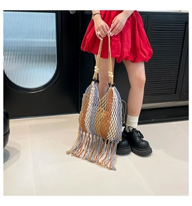 Close-up of the colorful striped woven bag with thick long tassels and wooden bead details