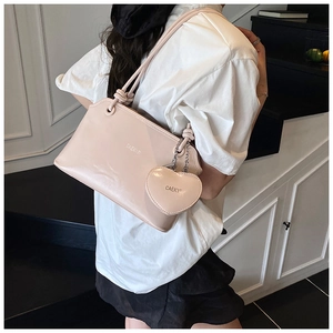 Détail d'un sac seau rose avec pendentif cœur et poignée nouée sur un mannequin