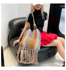 Detail of colorful woven tote bag featuring hollow mesh, wooden beads, and long fringe