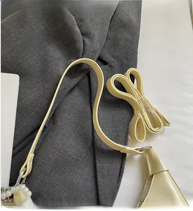 Detail of cream leather handbag featuring silver hardware and decorative pearl beads