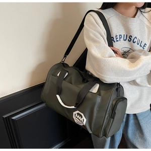Dettaglio della grande borsa verde con tessuto in nylon resistente e tracolla nera