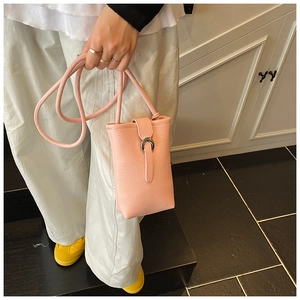 Detail of pink lychee leather phone bucket bag with silver metal ring buckle accent