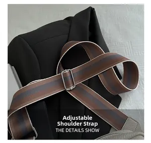Detail of adjustable striped shoulder strap with silver metal buckle on a casual bag