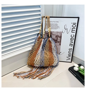 Detail of bohemian hand-woven tote bag with colorful tassels and wooden beads