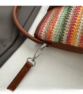 Detail of silver metal lobster clasp and D-ring on rainbow woven shoulder bag