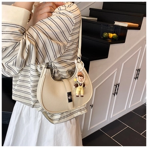 Detail of creamy white crescent shoulder bag with pebble grain leather and silver buckle