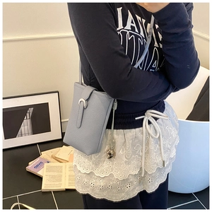 Détail du sac seau bleu clair avec boucle fer à cheval en argent et texture cuir grainé