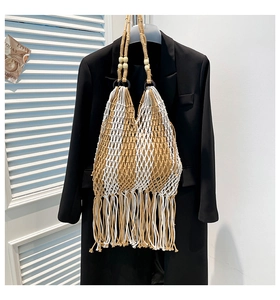 Macro detail of hand-woven mesh tote bag featuring long tassels and wooden bead accents