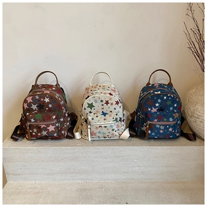 Three mini canvas backpacks with colorful stars on stairs in brown, beige and blue colors