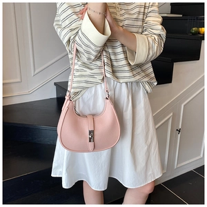 Close-up of pink hobo bag with grainy texture and silver piston lock detail